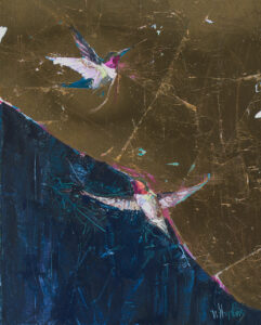 Two hummingbirds fly towards each other over a dark blue and gold leaf background.